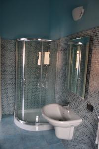 a bathroom with a shower and a sink and mirror at Villa Donna Maria in Capoterra