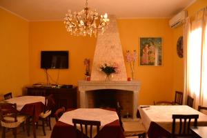 a dining room with two tables and a fireplace at Villa Donna Maria in Capoterra