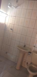 Acomodaçaoes koynonya في سيت لاغواس: حمام ابيض مع مرحاض ومغسلة