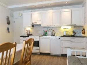 una cucina bianca con armadi bianchi e tavolo di Holiday Home Einola by Interhome a Laiska
