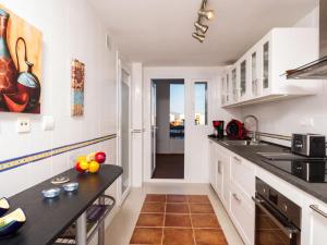 a kitchen with white cabinets and a black counter top at Apartment Reina Sofia II by Interhome in Estepona