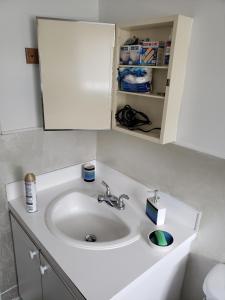 La salle de bains est pourvue d'un lavabo blanc et d'une armoire. dans l'établissement Downtown apartment next to highway netflix+wifi, à Edmundston