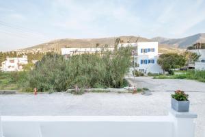 un estacionamiento con un edificio blanco y algunas plantas en Agia Anna Apartments, en Parikia