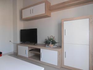 sala de estar con TV en un soporte de madera en Paneras del Rey, en Ávila