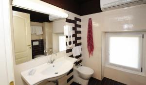 a bathroom with a sink and a toilet and a mirror at Residence Villa Maurice in Stresa +34 photos