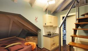 Cette chambre mansardée comprend un lit et un escalier. dans l'établissement Residence Villa Maurice, à Stresa