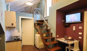 a living room with a staircase and a tv on the wall at Residence Villa Maurice in Stresa