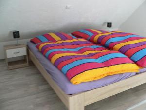 a bed with colorful blankets and pillows on it at Ferienhaus Zum grünen Holz in Zetel