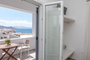 Habitación con balcón con mesa y vistas al océano. en Naxos Illusion Nikos Verikokos, en Naxos Chora