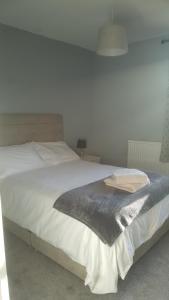 a bedroom with a large bed with white sheets at The Buck Inn in Buckden