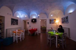 a woman sitting at a table in a restaurant at Ostello Palazzo Pierantoni in Foligno