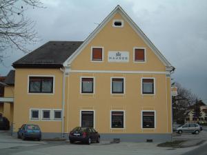 un edificio amarillo con una señal de mercado. en Maurer Gasthof-Vinothek, en Gleisdorf