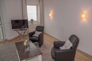 a living room with two chairs and a flat screen tv at 107_1 Helgoland in Wilhelmshaven