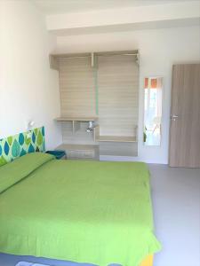 una camera con letto verde e finestra di Hotel & Residence Al Mare a Lido di Jesolo