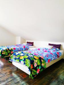 ヘウムにあるApartament Family & Comfortのカラフルな掛け布団付きの客室内のベッド2台