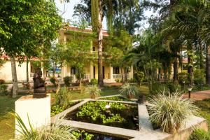 a garden with a pond in front of a building at Hotel Rainforest in Sauraha