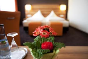 a vase with flowers on a table in a hotel room at Hotel Hirsch in Leonberg