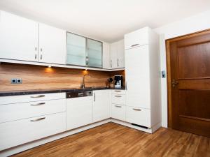 a kitchen with white cabinets and a wooden door at Ferienhaus Meissnitzer in Haus im Ennstal