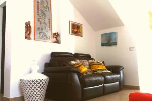 a black leather couch in a living room at Villa A DUE PASSI DAL MARE in Taranto +9 photos