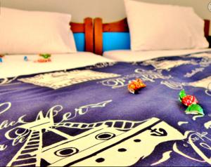 a bed with a purple comforter with a clock on it at Studios Elina in Skala Potamias +1 photo