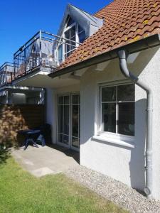 a white house with a balcony and a patio at Ferienwohnung Sonneneck Poel in Timmendorf