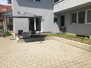 a patio with an umbrella and a table and chairs at Studio apartman Valentina in Velika Mlaka