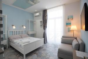 a bedroom with a bed and a chair and a window at Nereidi Suites in Salerno