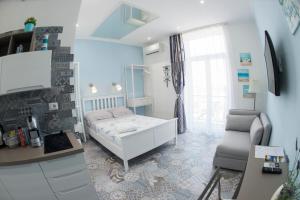 Habitación pequeña con cama y escritorio. en Nereidi Suites, en Salerno