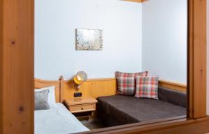 フィーバーブルンにあるPension Maislingerのソファとベッド付きの小さな部屋です。