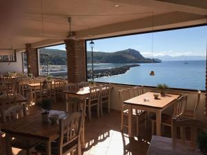 een restaurant met tafels en stoelen en uitzicht op de oceaan bij Albergo Tirreno in Marina di Camerota