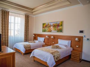 a hotel room with two beds and a tv at Hotel Boka in Tirana +75 photos