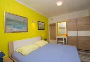 um quarto com uma cama e uma parede amarela em One bedroom apartment near the Kamenjak park in Prematura em Premantura