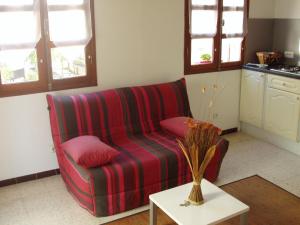 ein Wohnzimmer mit einem roten Sofa und einem Tisch in der Unterkunft maison de vacance in Pomérols
