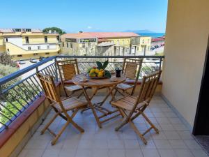 un tavolo e sedie su un balcone con un cesto di frutta di Living Piraino casa vacanze a Piraino
