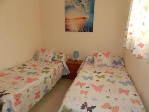 a bedroom with two beds and a picture on the wall at Trotamundos GC FAMILIAS Y ADULTOS RESPONSABLES in El Tablero
