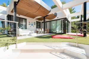 a home with a large open patio with red pillows at Nyumba ya Sun in Cala Tarida