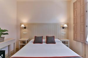 1 dormitorio con 1 cama blanca grande y 2 almohadas en Hostal La Chata by Vivere Stays, en La Granja de San Ildefonso
