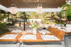 a wooden table with white plates and glasses on it at Nyumba ya Sun in Cala Tarida
