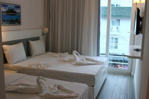 two beds in a hotel room with towels on them at LİMAN BOUTIQUE OTEL in Kemer