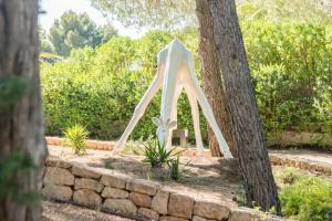 a white altar in a garden between two trees at Nyumba ya Sun in Cala Tarida +36 photos