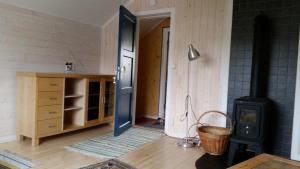 um quarto com um fogão a lenha e uma porta em The Blue House at The End Of The World II em Mehamn