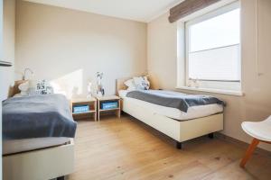 two beds in a bedroom with a window at Buedlfarm-Wohlfuehlhuette in Fehmarn