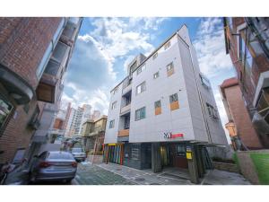 a tall white building on a city street at BB Hongdae Line in Seoul