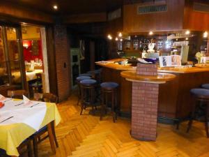 ein Restaurant mit einer Bar und einigen Tischen und Stühlen in der Unterkunft Gasthaus Storchen Hellas in Haslach im Kinzigtal
