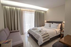 ナフプリオにあるNafplia Terraのベッドルーム1室(ベッド1台、ソファ、窓付)