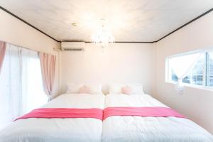 um quarto com uma cama grande e um lustre em 9 min to Yokkaichi Tomida STN House em Yokkaichi