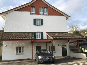 un'auto parcheggiata di fronte a una casa bianca di Ferienwohnung Erlinsbach SO a Niedererlinsbach