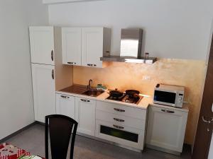 una pequeña cocina con fregadero y microondas en Living Piraino casa vacanze en Piraino