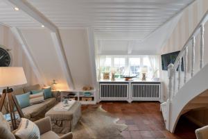 a living room with a staircase with a couch and a table at Alte Mühle direkt am Wattenmeer in Keitum