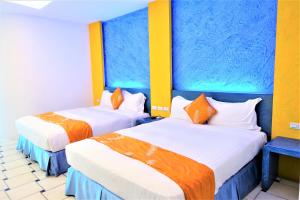 duas camas num quarto com azul e amarelo em Yujian Kending Tese Homestay em Kenting
